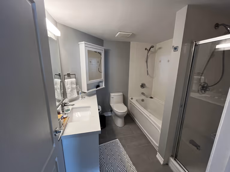 Modern bathroom with shower, toilet and sink.