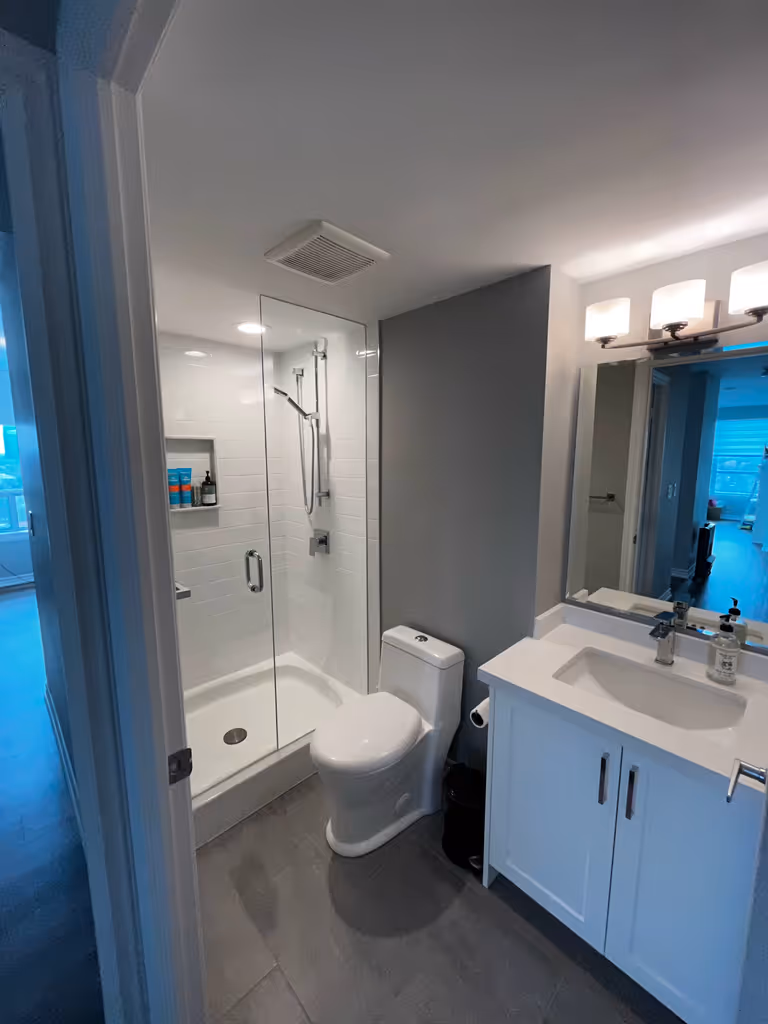 Modern bathroom with shower, toilet and sink.