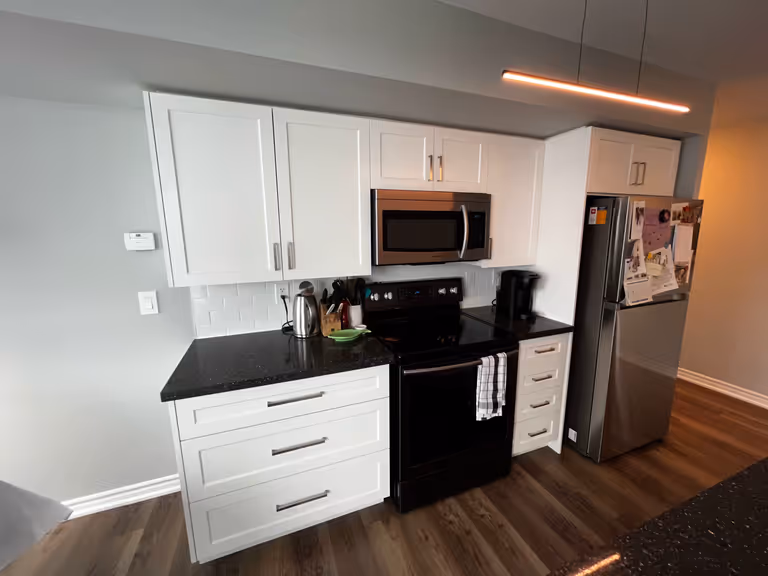 A kitchen with sleek white cabinets and contrasting black counter tops, creating a modern and stylish ambiance.