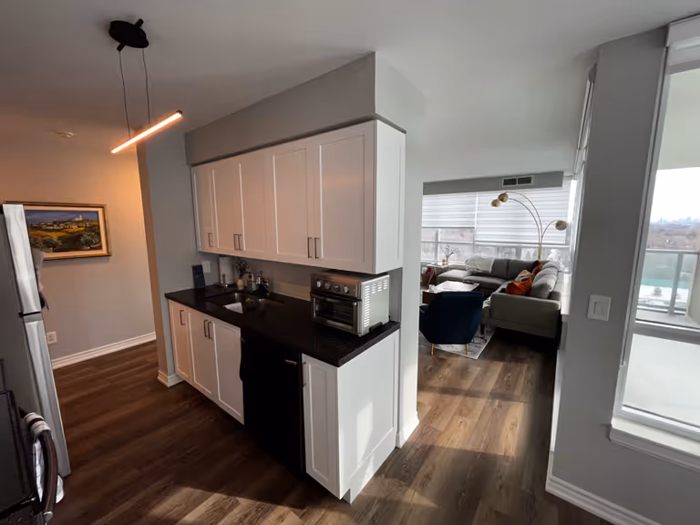 White cabinets and black counter tops in a modern kitchen.
