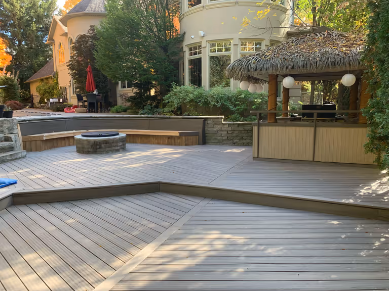 A cozy outdoor space featuring a deck adorned with a fire pit and a patio, perfect for relaxation and gatherings.