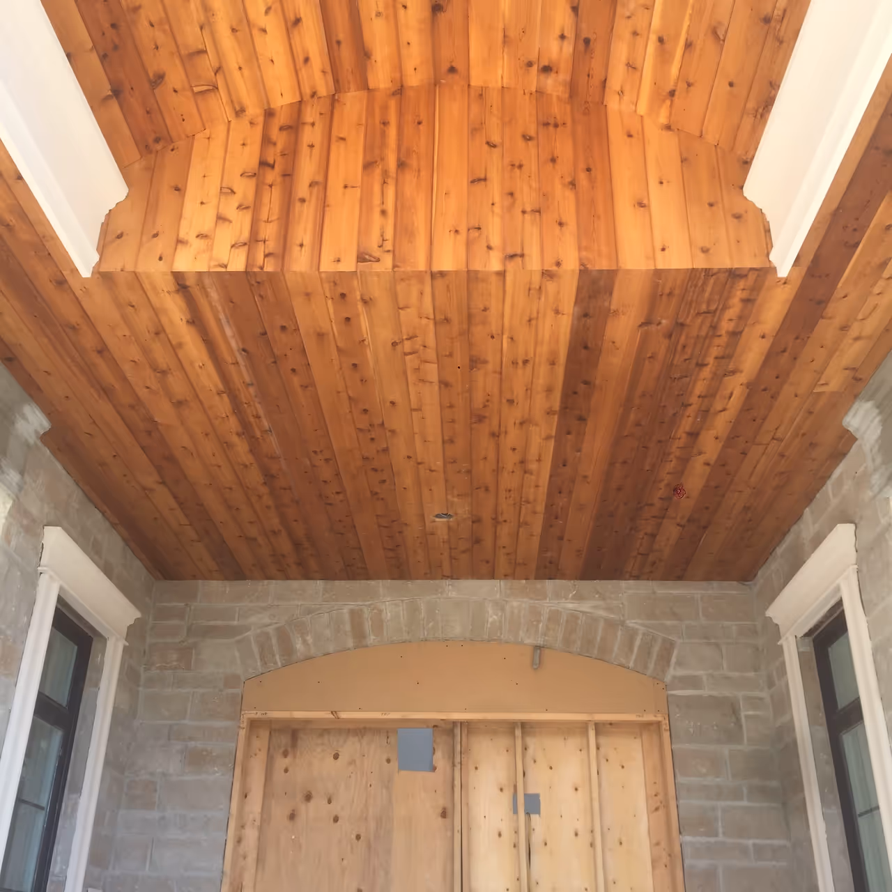 A wooden ceiling with two wooden doors, showcasing the rustic charm of the interior design.