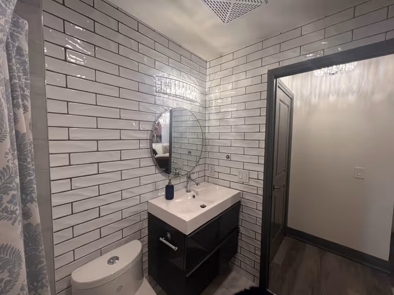 Modern bathroom with black fixtures and white tiles.